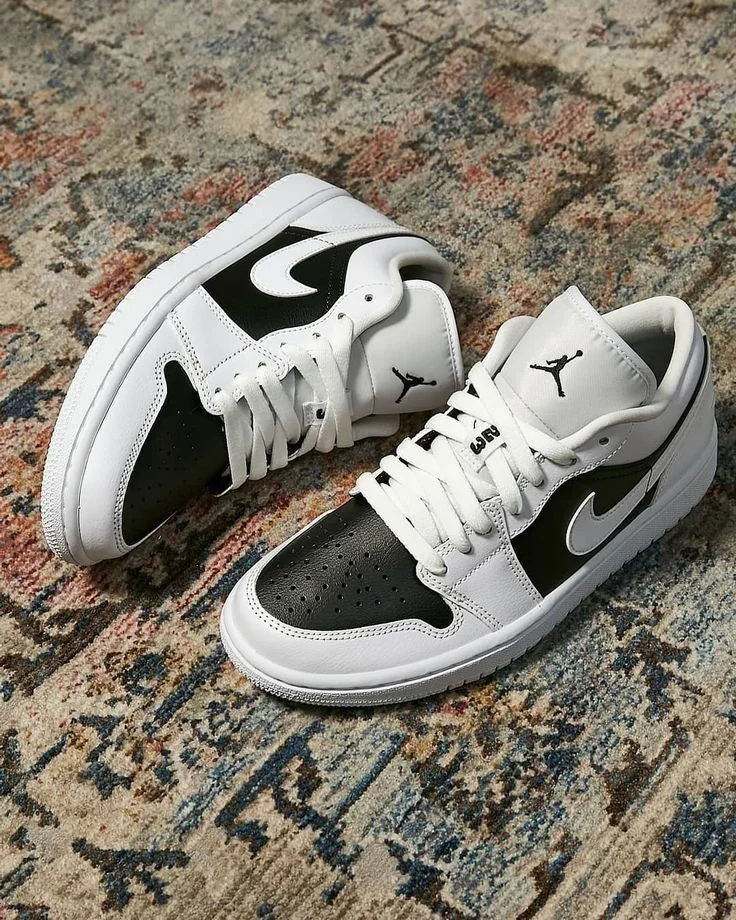 Sneakers preto e branco sobre superfície de pedra